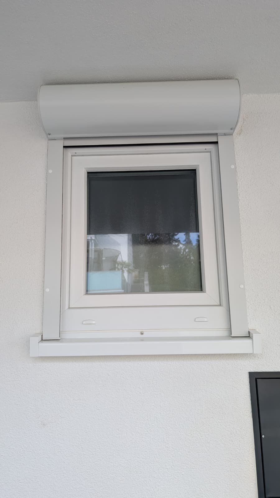 Fenster mit Rollladen in einer hellen Laibung