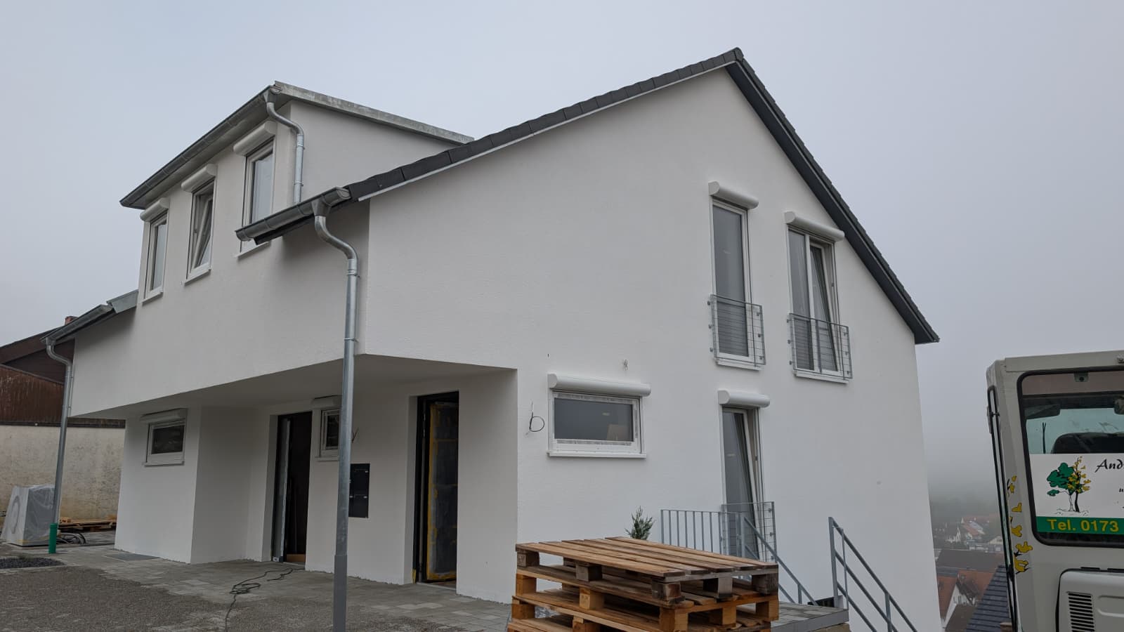Wohnhaus mit weißen Vorbaurollläden und Rundkästen
